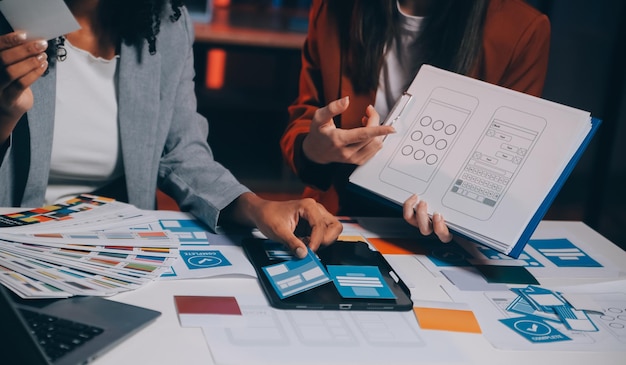 Un equipo de diseñadores web de UI UX están trabajando juntos para desarrollar sitios web adaptados a dispositivos móviles Mobile Mockup