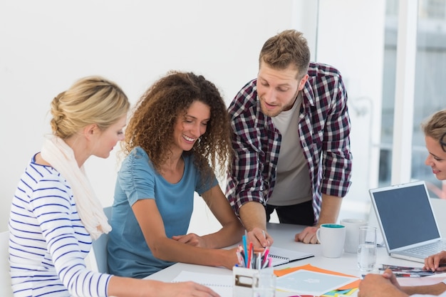 Equipo de diseño feliz joven lluvia de ideas juntos