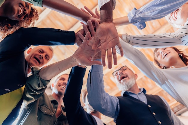 Equipo de diversas personas en él como un grupo de empresarios que unen sus manos en solidaridad apilando el concepto de manos foto de archivo