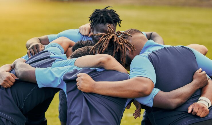 Foto el equipo de diversidad y los hombres se apiñan en los deportes para apoyar la motivación o los objetivos al aire libre. el grupo deportivo de hombres y el rugby se unen para el trabajo en equipo o el éxito en colaboración antes del partido o el juego.