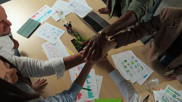 Equipo diverso feliz del primer de la gente de negocios junta las manos aplaudir y celebrar el éxito en el trabajo en equipo del grupo empresarial de la oficina en el espacio de coworking del estilo de vida de la gente del edificio del equipo de oficina