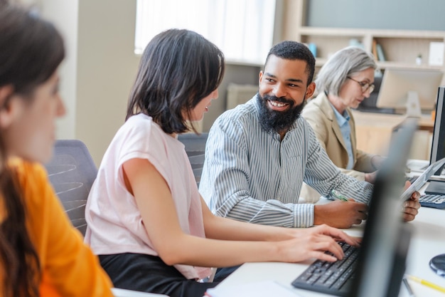 Un equipo diverso de programadores trabajando en computadoras en una oficina moderna