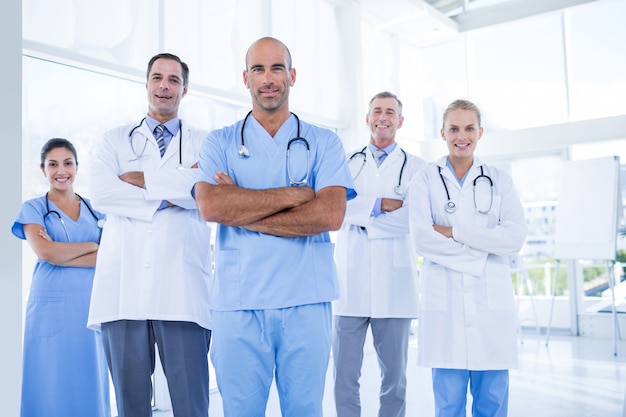 Equipo de doctores sonrientes que miran la cámara con los brazos cruzados