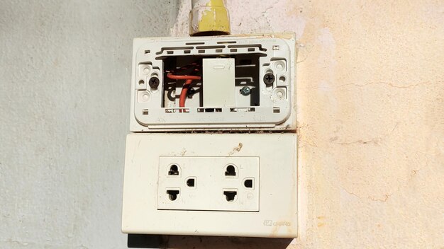 Equipo eléctrico vintage en una pared blanca sucia con un viejo interruptor de energía panel de puerta antigua