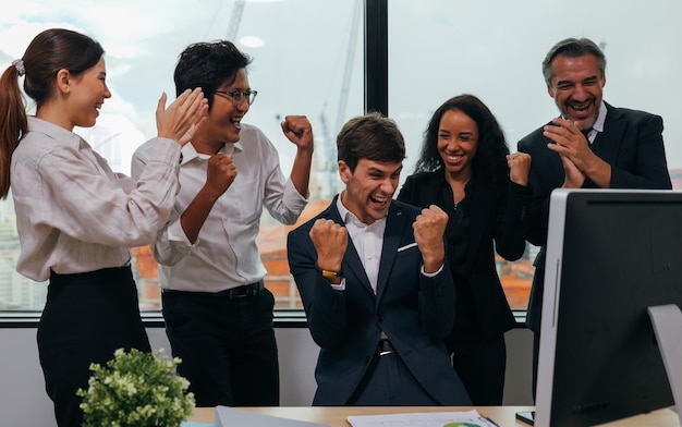 Equipo de empleados de negocios felices celebrando el éxito con elogios en la sala de reuniones