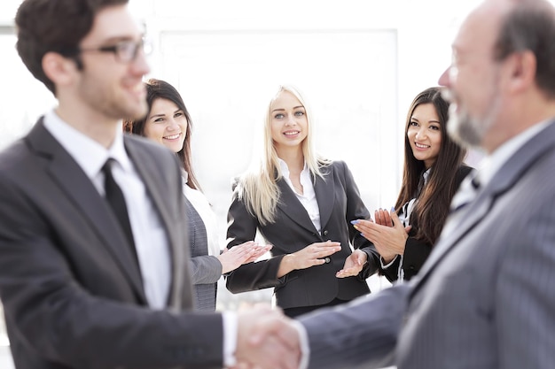 Equipo empresarial aplaudiendo a los socios comerciales después de firmar el contrato