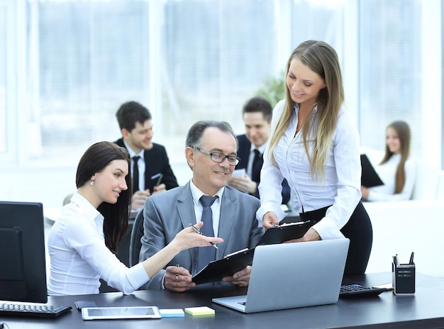 Equipo empresarial discutiendo con el jefe de datos financieros.