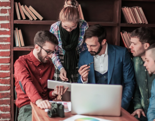 Equipo empresarial discutiendo un nuevo proyecto publicitario de la empresa en una oficina moderna