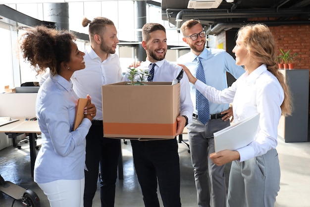 El equipo empresarial se encuentra con un nuevo empleado en una gran oficina moderna.