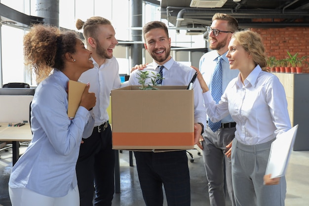 El equipo empresarial se encuentra con un nuevo empleado en una gran oficina moderna.