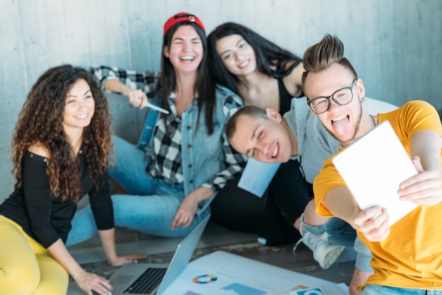 equipo empresarial milenario trabajando juntos. diverso grupo de jóvenes sentados en el suelo.