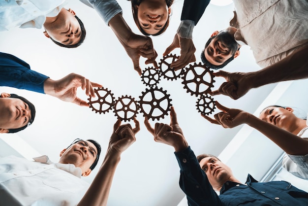 El equipo empresarial que se une a la rueda dentada en forma circular simboliza un grupo exitoso de asociación empresarial y un fuerte trabajo en equipo de unidad colectiva en el lugar de trabajo comunitario con eficiencia productiva Prudente