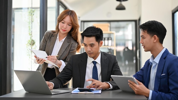 Un equipo de empresarios asiáticos inteligentes y profesionales que intercambian ideas y trabajan juntos