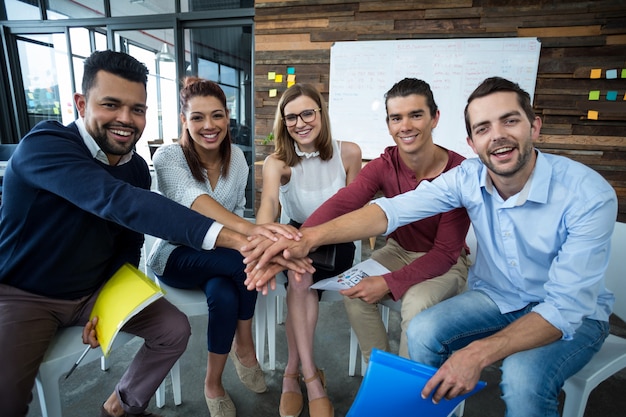 Foto equipo de empresarios formando pila de mano en la oficina