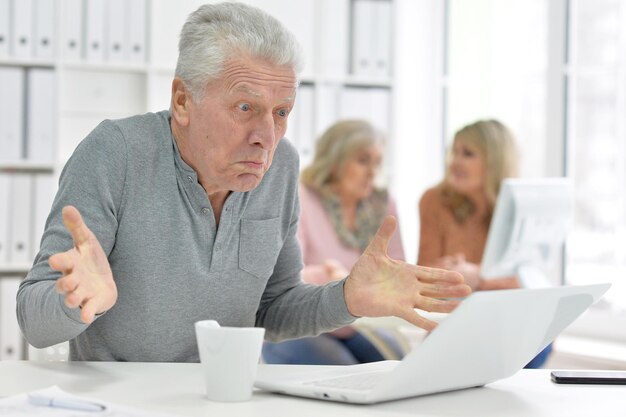 Equipo de empresarios que trabajan junto con una computadora en la oficina