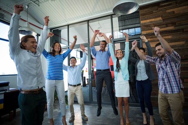 Equipo de empresarios saltando en la oficina