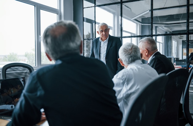 Equipo envejecido de arquitectos de negocios de edad avanzada tiene una reunión en la oficina.