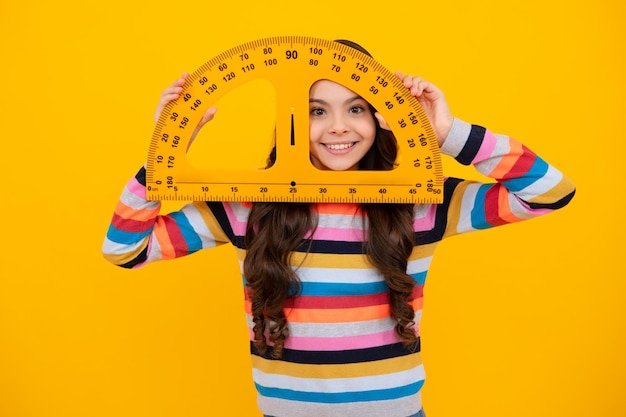 Equipo escolar de medición Colegiala sosteniendo la medida para la lección de geometría aislada sobre fondo amarillo Matemáticas de estudio de estudiante Adolescente feliz emociones positivas y sonrientes de colegiala