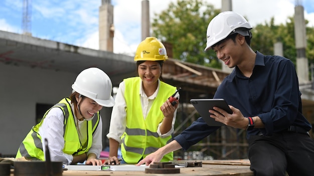 Equipo de especialistas e ingenieros civiles que inspeccionan el sitio de construcción de edificios industriales