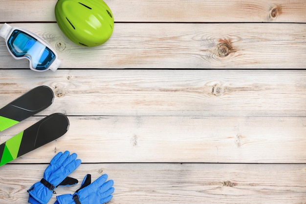 Equipo de esquí en mesa de madera con espacio de copia Composición de vista superior plana Concepto de servicio de esquí