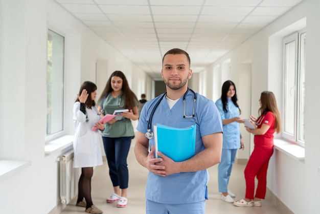 Equipo de estudiantes de medicina caucásicos con uniformes en la universidad o en el pasillo de una clínica moderna