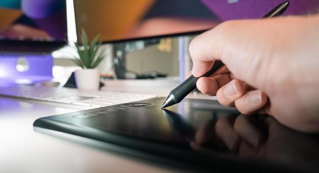 Equipo de estudio de diseñador gráfico Con la pluma digital en la mano Interior de la oficina en el hogar