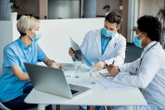 Equipo de expertos médicos que examinan la radiografía de un paciente en la clínica