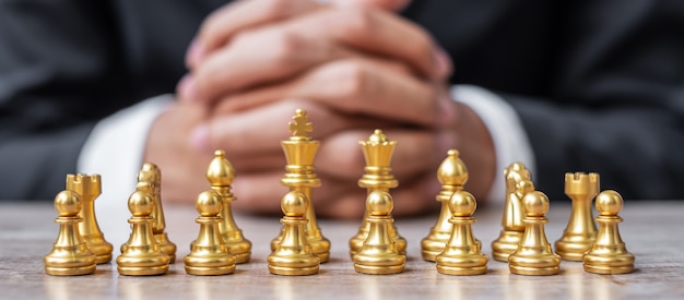 Equipo de figuras de ajedrez dorado (rey, reina, alfil, caballero, torre y peón) con antecedentes de gerente de negocios.
