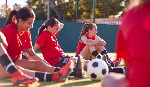 Foto equipo de fútbol femenino estirándose mientras entrena para un partido de fútbol