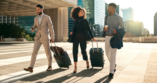 Foto equipo de gente de negocios caminando y viajando con maleta en la ciudad para oportunidades de trabajo corporativo y creación de redes mujer y hombres profesionales hablando en un hotel al aire libre o en el camino al aeropuerto con equipaje