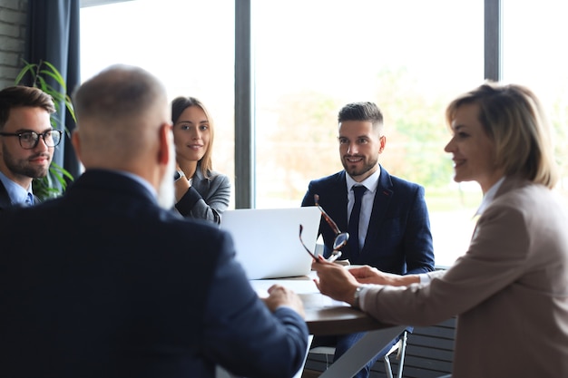 Equipo de gente de negocios que tiene discusión en la mesa en la oficina creativa.