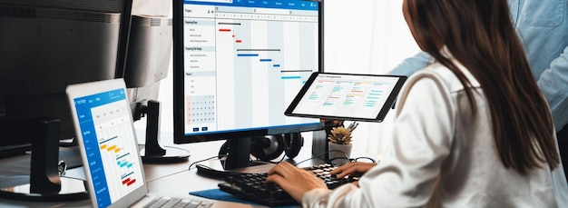 Equipo de gestión de proyectos coordinando y actualizando el cronograma planificado del proyecto en la computadora usando el software de diagrama de Gantt en la oficina Gente de negocios planificando el tiempo y la fecha límite para la tarea de la empresa Pioneros
