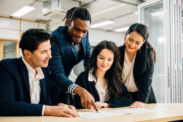 Un equipo global con una mujer líder colabora en una sala de reuniones Su trabajo en equipo es evidente mientras discuten los resultados financieros Comparten ideas y estrategias de lluvia de ideas para el éxito