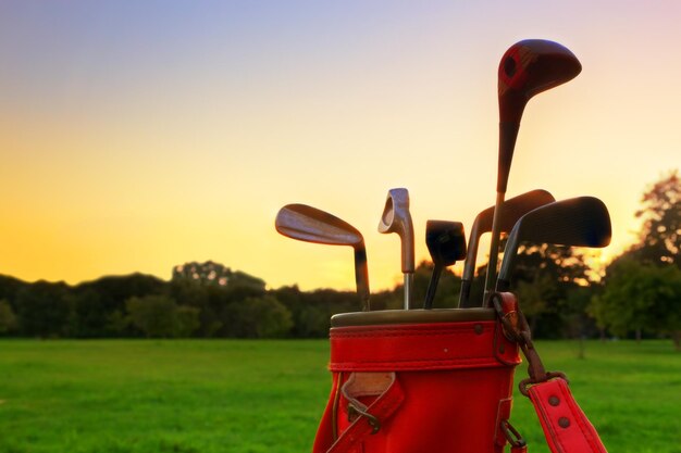 Foto equipo de golf palos de golf profesionales al atardecer