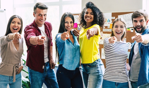 Equipo hipster exitoso en coworking. Autónomos. Grupo de jóvenes empresarios están trabajando juntos en la oficina moderna. Amigos estudiantes felices