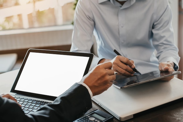 Equipo de hombres de negocios o analistas de datos financieros que trabajan juntos con tabletas y computadoras portátiles y gráficos de datos Plan para analizar proyectos en la oficina