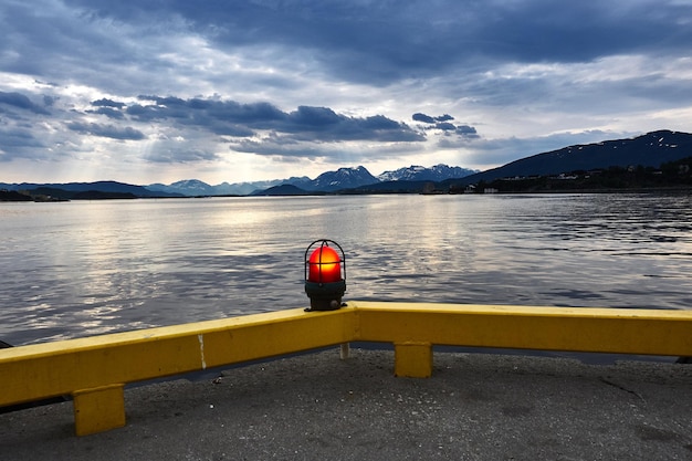 Foto equipo de iluminación iluminado en la orilla del lago contra el cielo