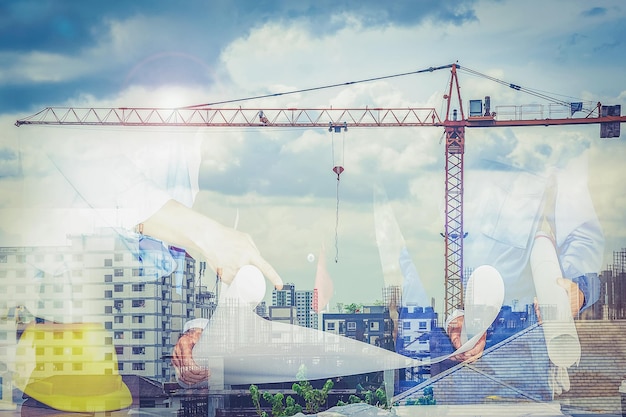Equipo de ingeniería con arquitectos y ascensores de grúa en el fondo esta es una doble exposición