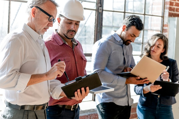 Equipo de ingeniería ecológico de pie junto a la ventana de vidrio.