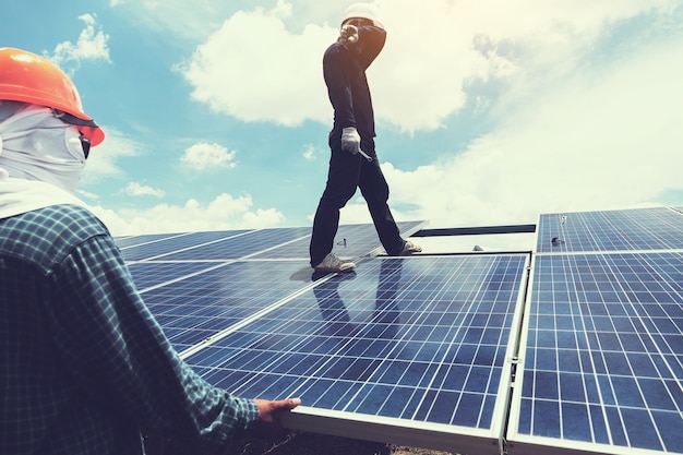 equipo de ingenieros y electricistas intercambiando e instalando paneles solares