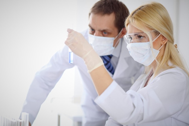 Foto equipo de investigación científica con solución clara en laboratorio.