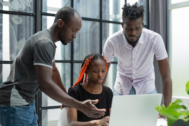 Equipo de jóvenes africanos en la oficina trabajando en una laptop