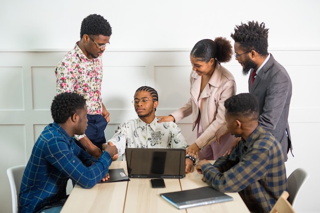 Equipo de jóvenes africanos que trabajan en la oficina en una mesa con un portátil