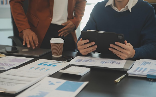 Equipo de jóvenes empresarios asiáticos tienen seriedad y desacuerdo en la reunión del equipo para el próximo proyecto de marketing y gestión de ventas con vista a rascacielos para el inicio de negocios y concepto de educación