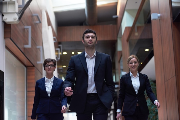 equipo de jóvenes empresarios caminando, grupo de personas en el interior de la oficina moderna