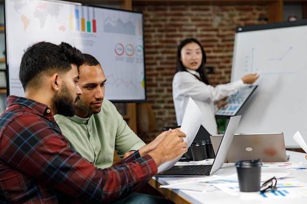 Un equipo de jóvenes empresarios multinacionales está trabajando en una empresa de trabajo en equipo de estrategia empresarial de inicio com