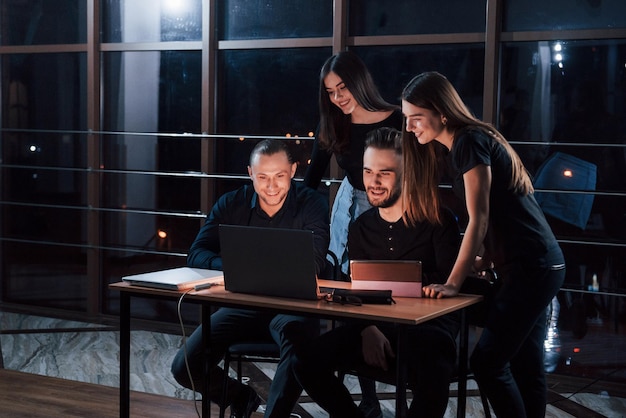 Un equipo de jóvenes empresarios trabaja en su proyecto por la noche en la oficina.