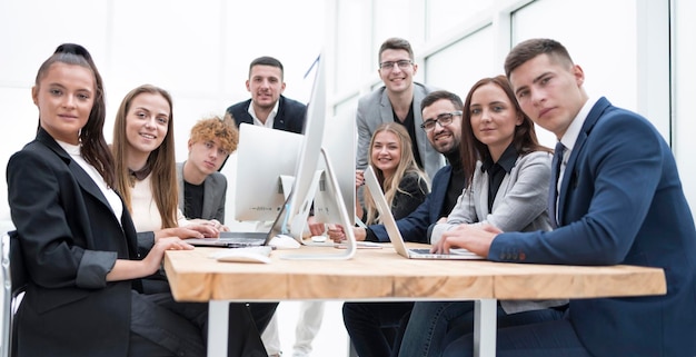 Equipo de jóvenes profesionales sentados en un escritorio de oficina