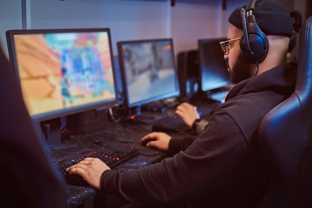 Un equipo de jugadores adolescentes juega en un videojuego multijugador en PC en un club de juegos.