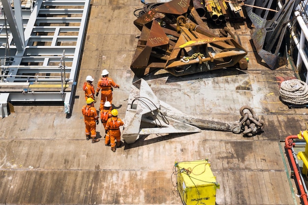 Foto un equipo de maquinistas preparando el anclaje en la cubierta de una barcaza de trabajo de construcción en un campo petrolífero en alta mar